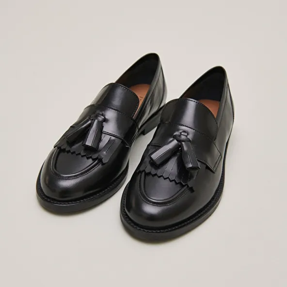 Flat heel loafers with tassels in black leather